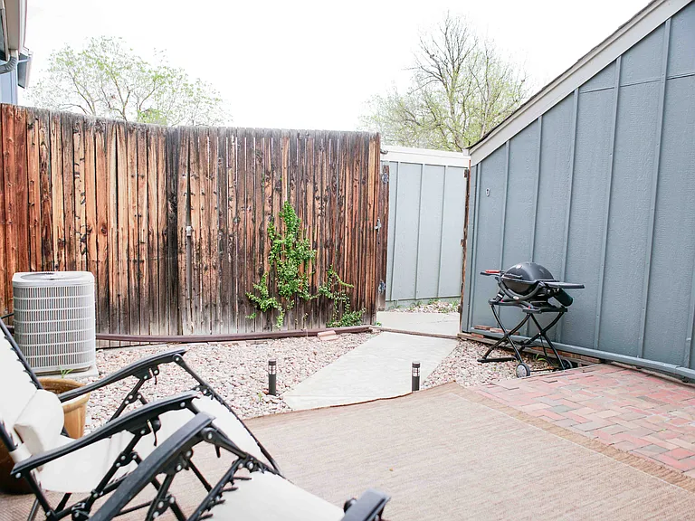 Back patio, fenced in with gate. Gate is open in this photo.