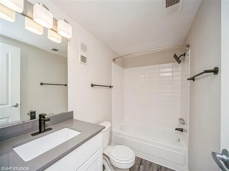 Full bathroom with updated lighting and grey vanity