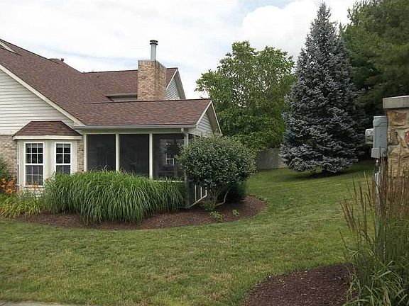 Exterior Back. Lovely side yard with perennials and large blue spruce tree.