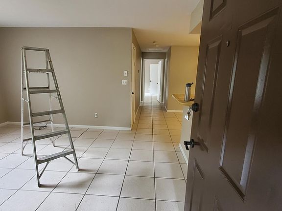 Living room looking from the front door. New ceiling fan being installed.