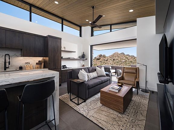 Open great room with fireplace, vaulted ceilings, and multi-slide patio door