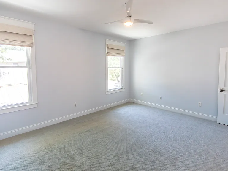 Bright windows in the primary suite. The room is very spacious big enough for a bench of sitting area by the windows.