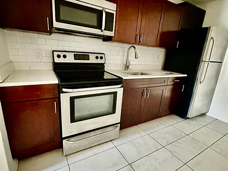 NEWLY refurbished kitchen with stainless steel appliances, tiled walls, floors, plumbing fixtures and new double pained glass windows.