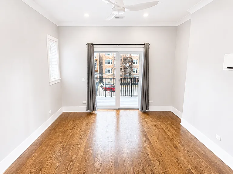Primary Bedroom with access to rear balcony, media ready wall for television and additional two windows.