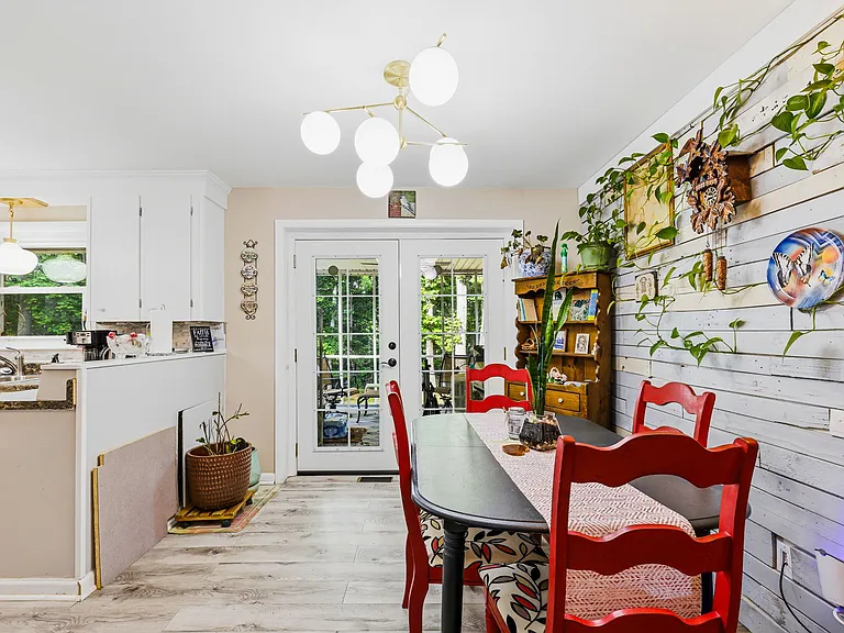 MAIN LEVEL: Dining Area, Double Opening French Doors (ahead lead to back porch) and Hall (on right) (Kitchen on left, Front Door behind Camera)