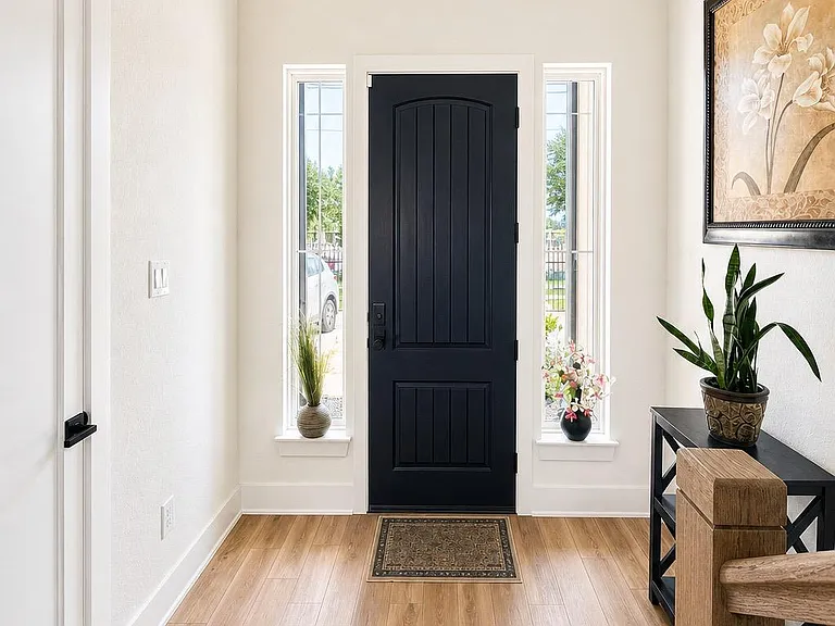 Welcoming entry foyer with wood-look flooring, high ceilings, and sidelights that bring in natural light at the front door.
