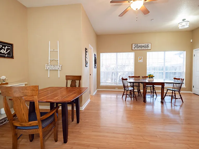 Spacious dining area with wood floors, multiple tables, and large windows for everyday meals or group gatherings.