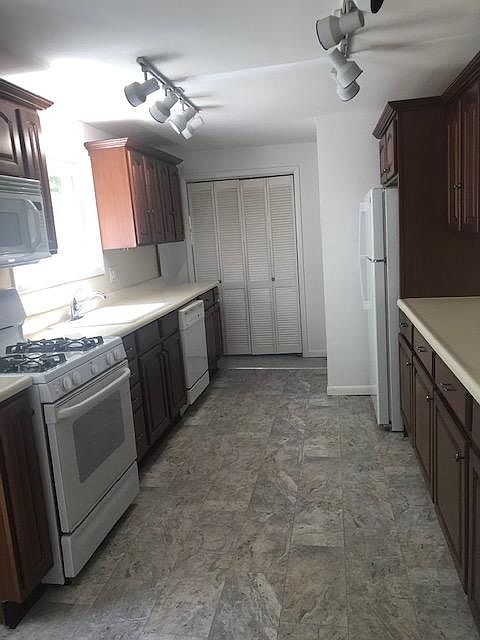 Kitchen area with pantry room that includes full size washer and dryer