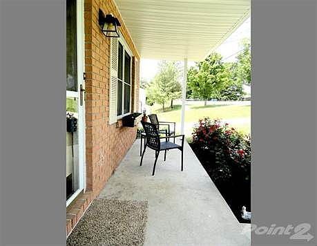 Covered front porch with lush landscaping greets you as you approach the home. Front door also boasts storm door for extra security/weather protection.