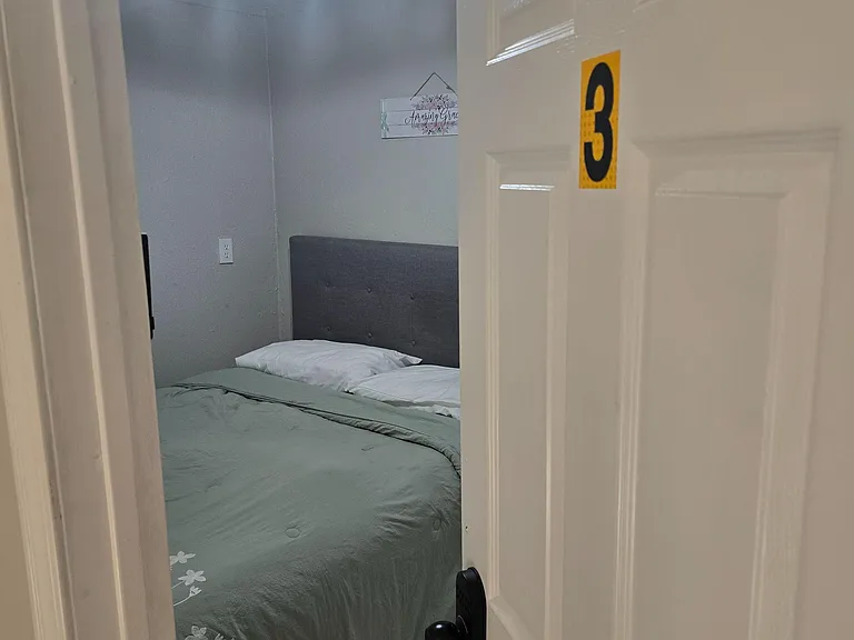 Furnished private bedroom featuring a comfortable bed, overhead lighting, and easy-care tile flooring.