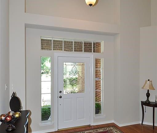 Inviting two-story foyer is naturally illuminated by transom, sidelights and second story window, and an updated chandelier for the evening.