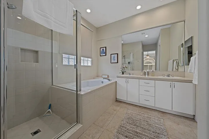 En suite bathroom to bedroom 2. Full tile shower and deck style tub along with dual sink vanities.