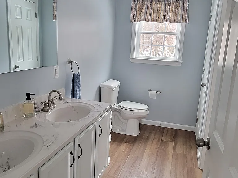 Full bathroom with double sink and separate shower/laundry area.