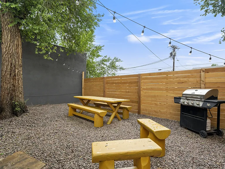 Enjoy your own fully fenced backyard with string lights, perfect for relaxing evenings or morning coffee.