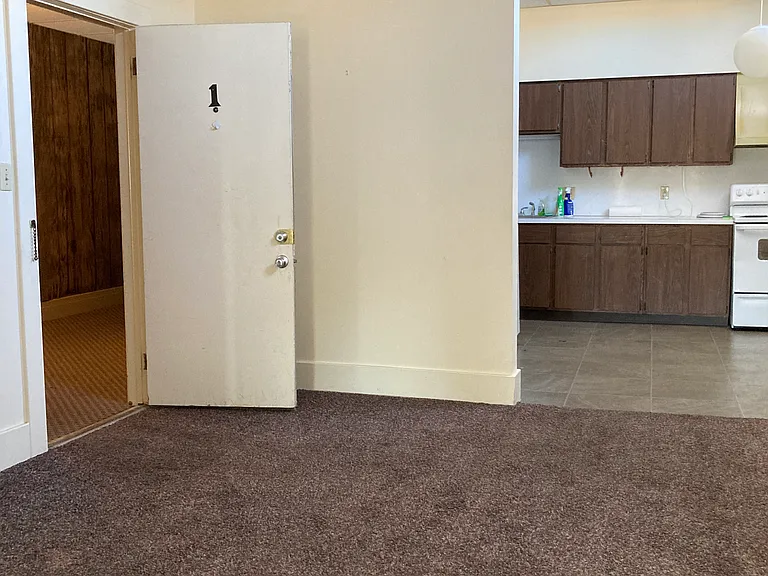 view from the far side of the living room back toward the kitchen and front entrance