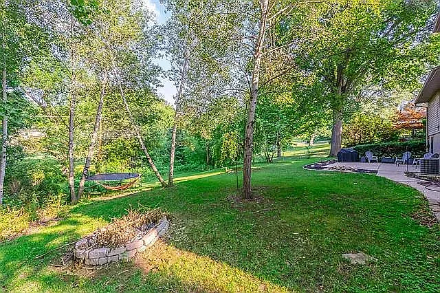 Back yard with firepit, garden, and patio with grill