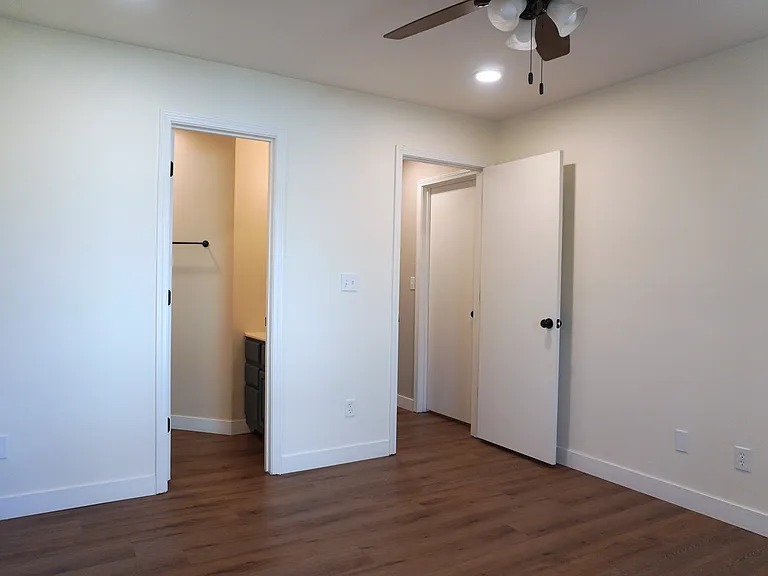 Spacious master bedroom with a walk-in closet, a private entry door to the outside patio, and a connected master bathroom for added convenience and privacy.