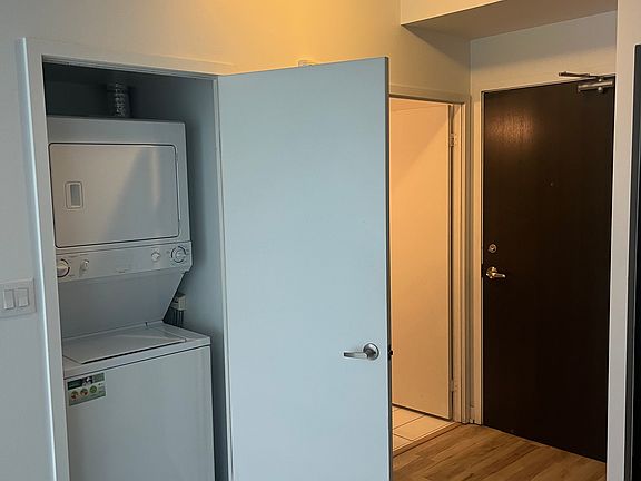 View of the laundry closet, bathroom, and door to the unit, from the kitchen area