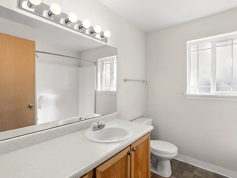 Spacious bathroom with full tub and bright vanity lighting. Spacious bathroom with full tub and bright vanity lighting.