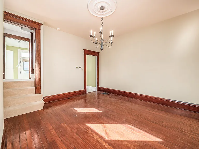 Dining room with access to the upstairs and wool carpeting on stairwell.