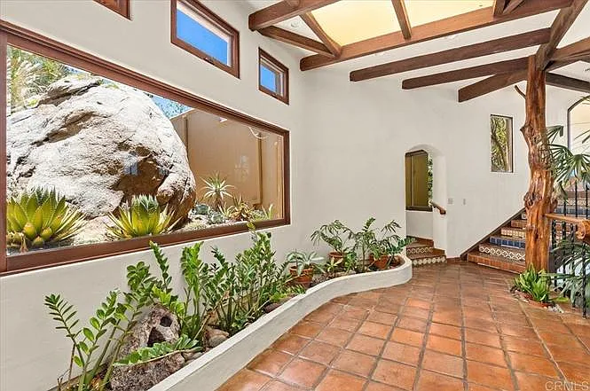Atrium has a picture window of a landscaped courtyard.
