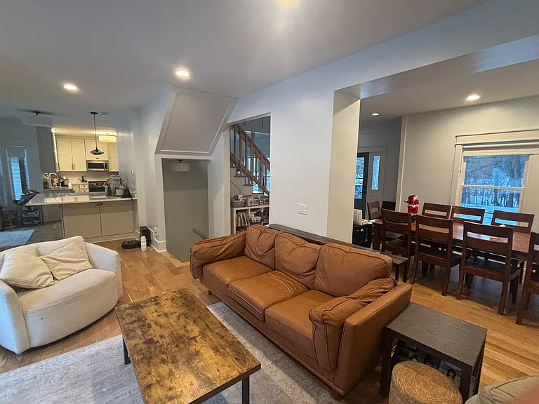 Main floor living area with open kitchen in background and dining area.