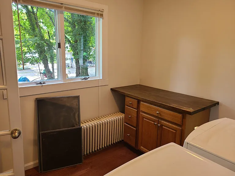 The laundry room has plenty of light with moderrn washer and dryer.
