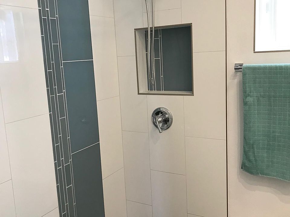 Drop down shower with black beach pebble floor and glass tile walls. Tankless hot water heater = endless supply of hot water.