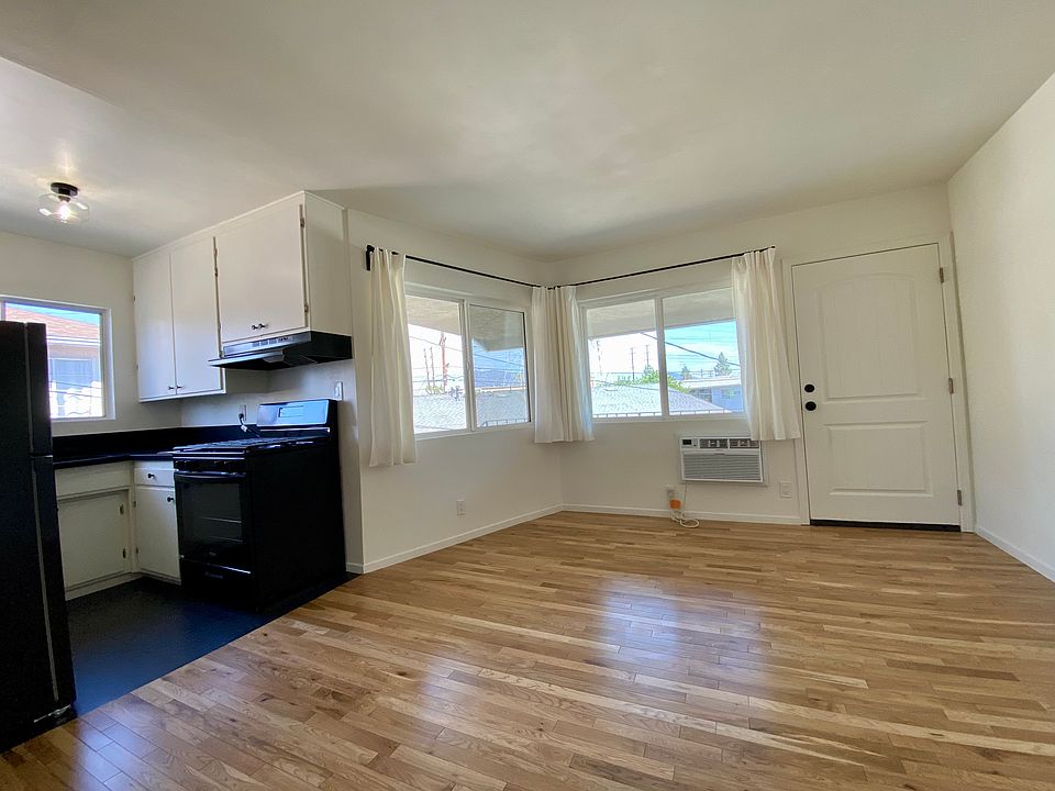 Living area with open kitchen concept. Newly hung curtains.
