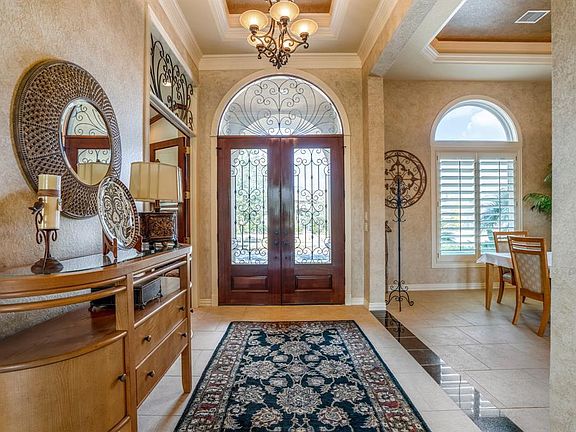 Looking back at the the intricate iron work on the double front doors, that allows light to reflect into the foyer of the home.