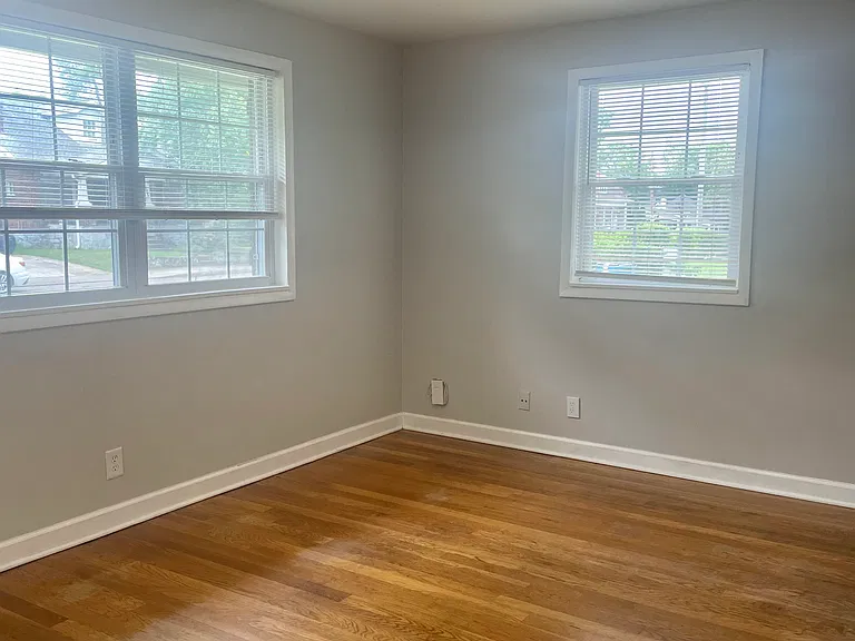 Living room with large south facing and smaller west facing windows.