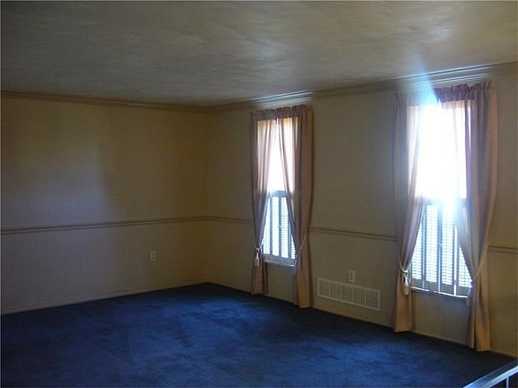 Large living room, chair rail, crown molding and access to dining room for nice entertaining space.