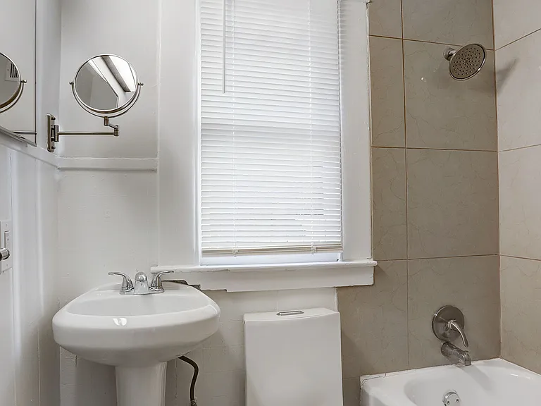Well-lit bathroom with cabinetry for storage.