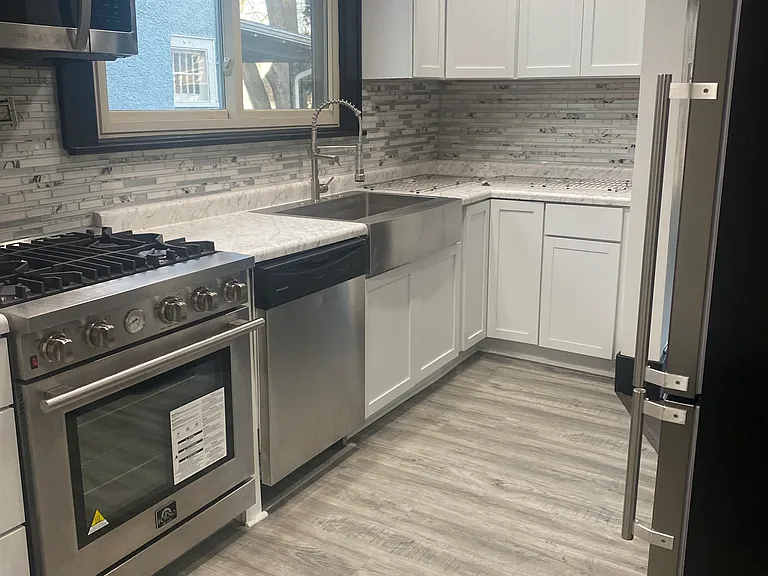 Kitchen gas range and stainless steel farm sink, micro wave and oven in stove. dishwasher.... skylights.