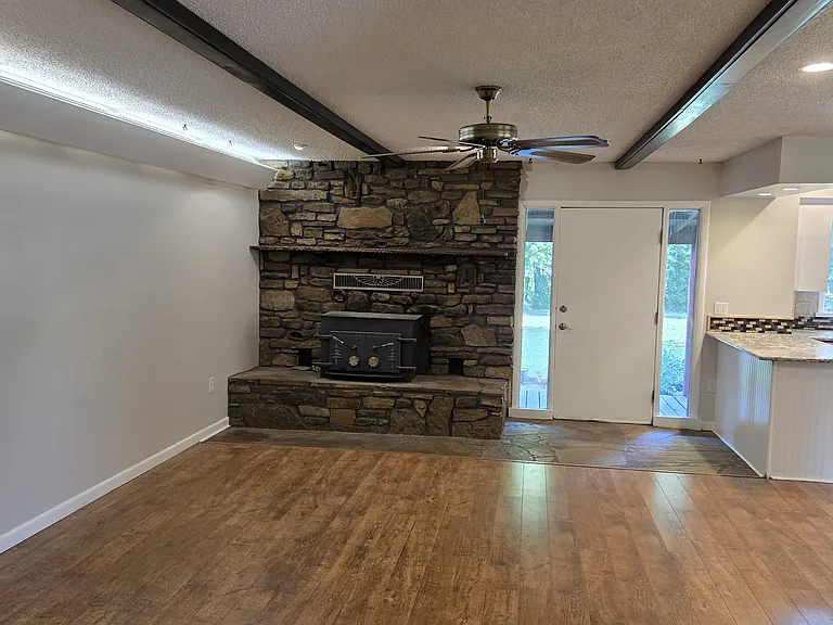 Family room showcasing rock work and wood stove