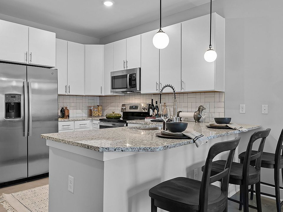 Kitchen with granite counters, stainless appliances, and subway tile backsplash