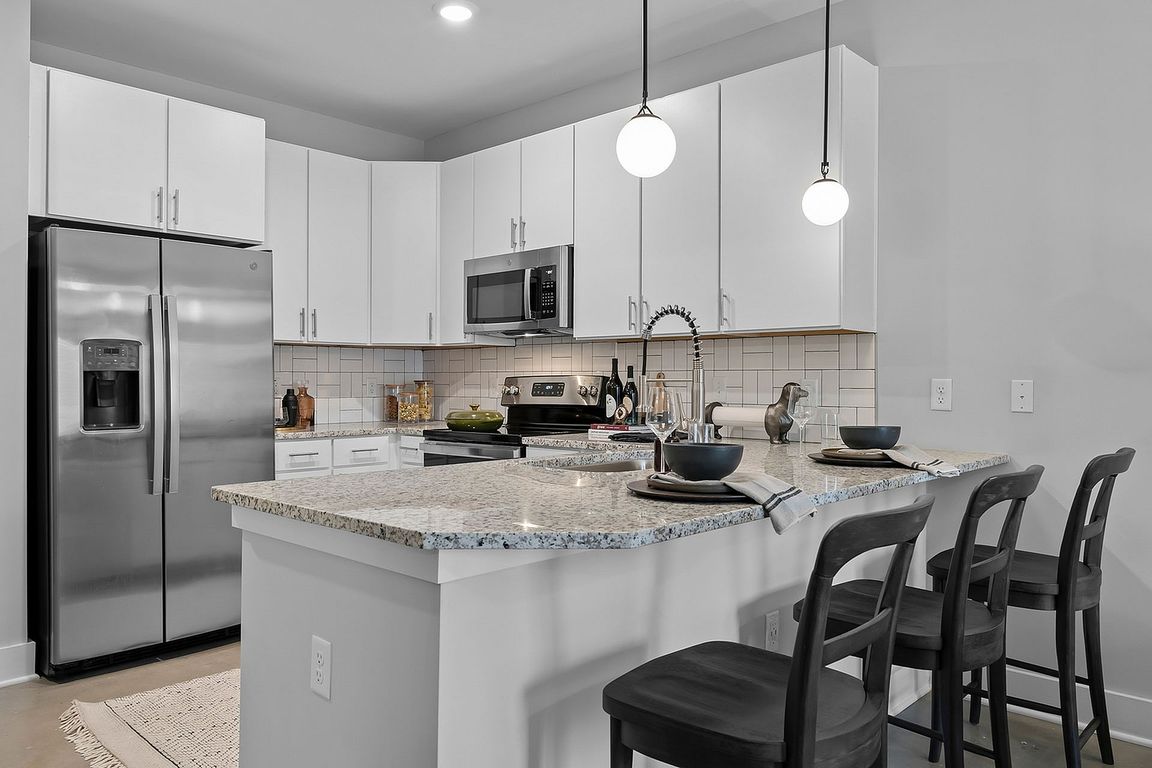 Kitchen with granite counters, stainless appliances, and subway tile backsplash