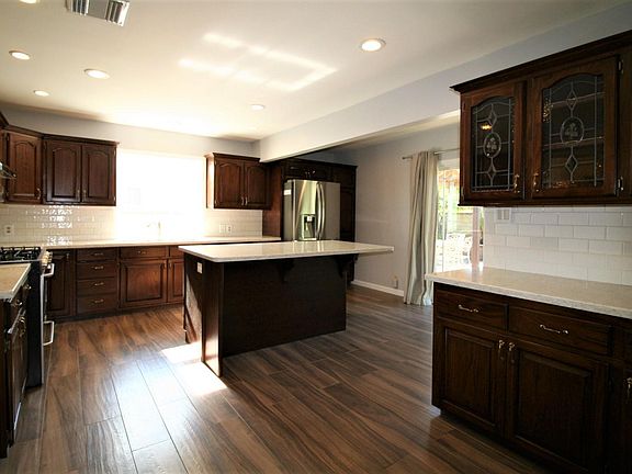Open kitchen with upgraded cabinets, counters and recessed lighting.