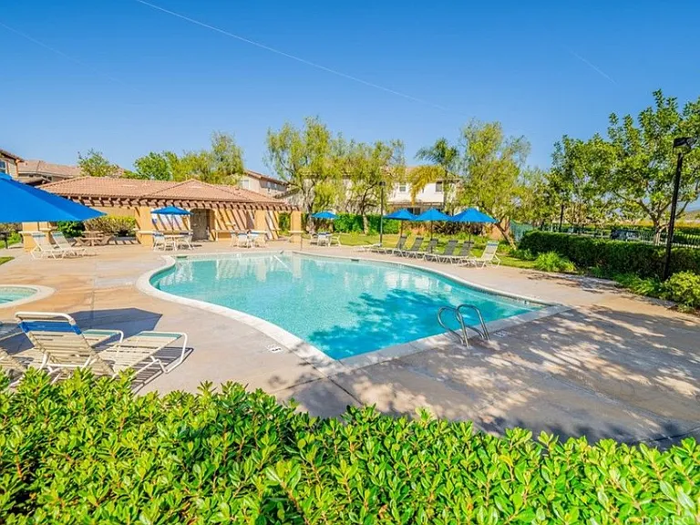 This picture shows the refreshing community pool and spa, with bathrooms and shade.