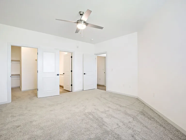 The primary suite at Garrett Harvest Junction West features a spacious walk-in closet and private en suite bath _ your own retreat in Longmont, CO.
