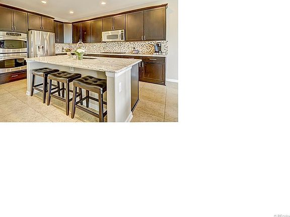 Kitchen upgrades feature fully tiled backsplash, slab granite, distressed cabinetry, SS appliances, gas cooking