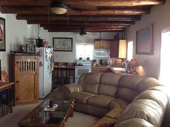 Sample of living room furnished. Kitchen at far end.