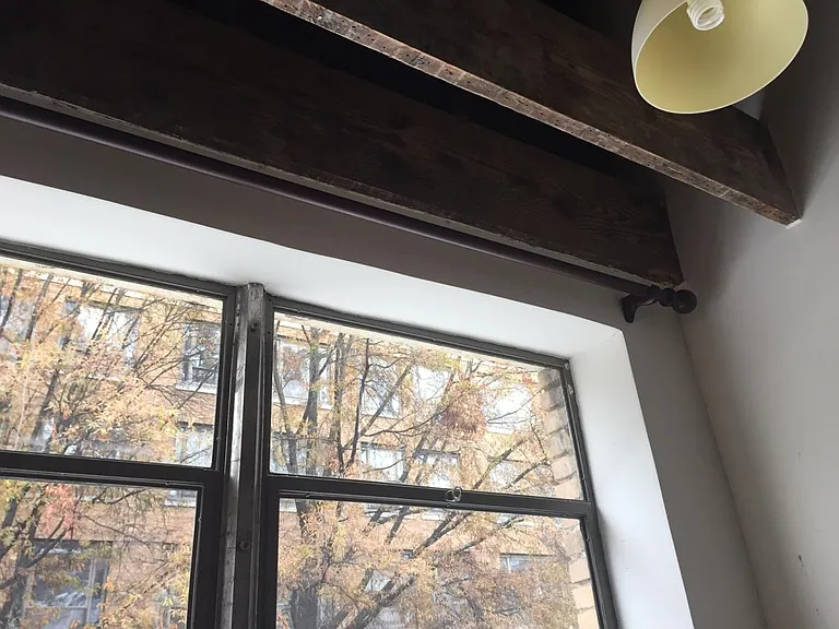 Tall windows and heavy wood curtain rods throughout