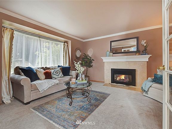 Bright livingroom with large window and gas fireplace.  