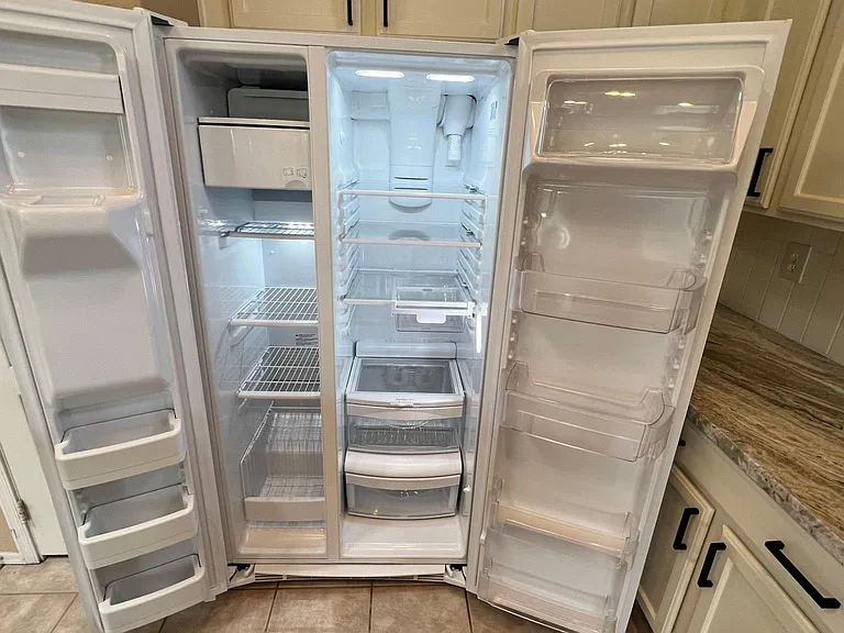 large side by side refrigerator with filtered ice and water dispenser and deli drawer, another big refrigerator & freezer in garage