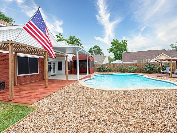 The oversized backyard offers multiple patio areas; an inviting salt water pool which was recently resurfaced; and an extended grassy area (not shown in photo).
