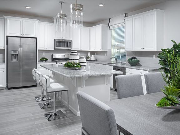 With a spacious center island and stainless steel appliances, this multifunctional kitchen serves as