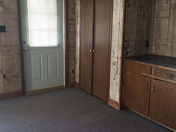 Front door view in living room with extra closet and TV cabinet