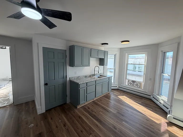 From left to right. Door opened to go to the bedroom; door to the bathroom; sink; south facing windows. The dual fan comes with the house - one fan blows in air and one fan blows out air; or both fans can blow out or in.