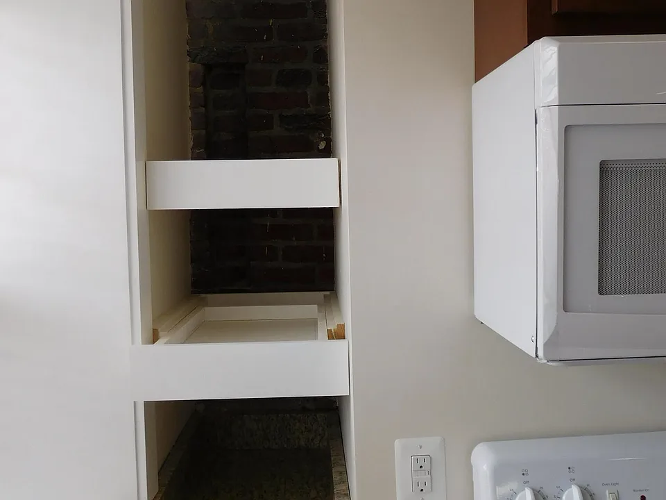 Pull out kitchen storage shelves in front of exposed 1859 br